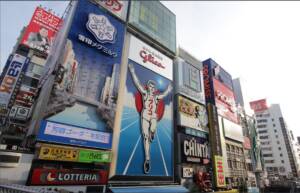KolaÅ¼ czterech zdjÄ™Ä‡: dwa przedstawiajÄ… miejskie krajobrazy z reklamami i sklepami w Japonii, a dwa inne to zrzuty ekranu z japoÅ„skich sklepÃ³w internetowych